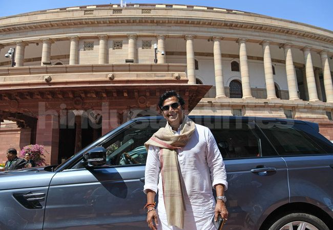 Ravi Kishan smiling with their car collection